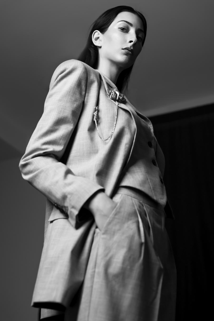 Black and white — grey tailoring seen from below, hand in pocket