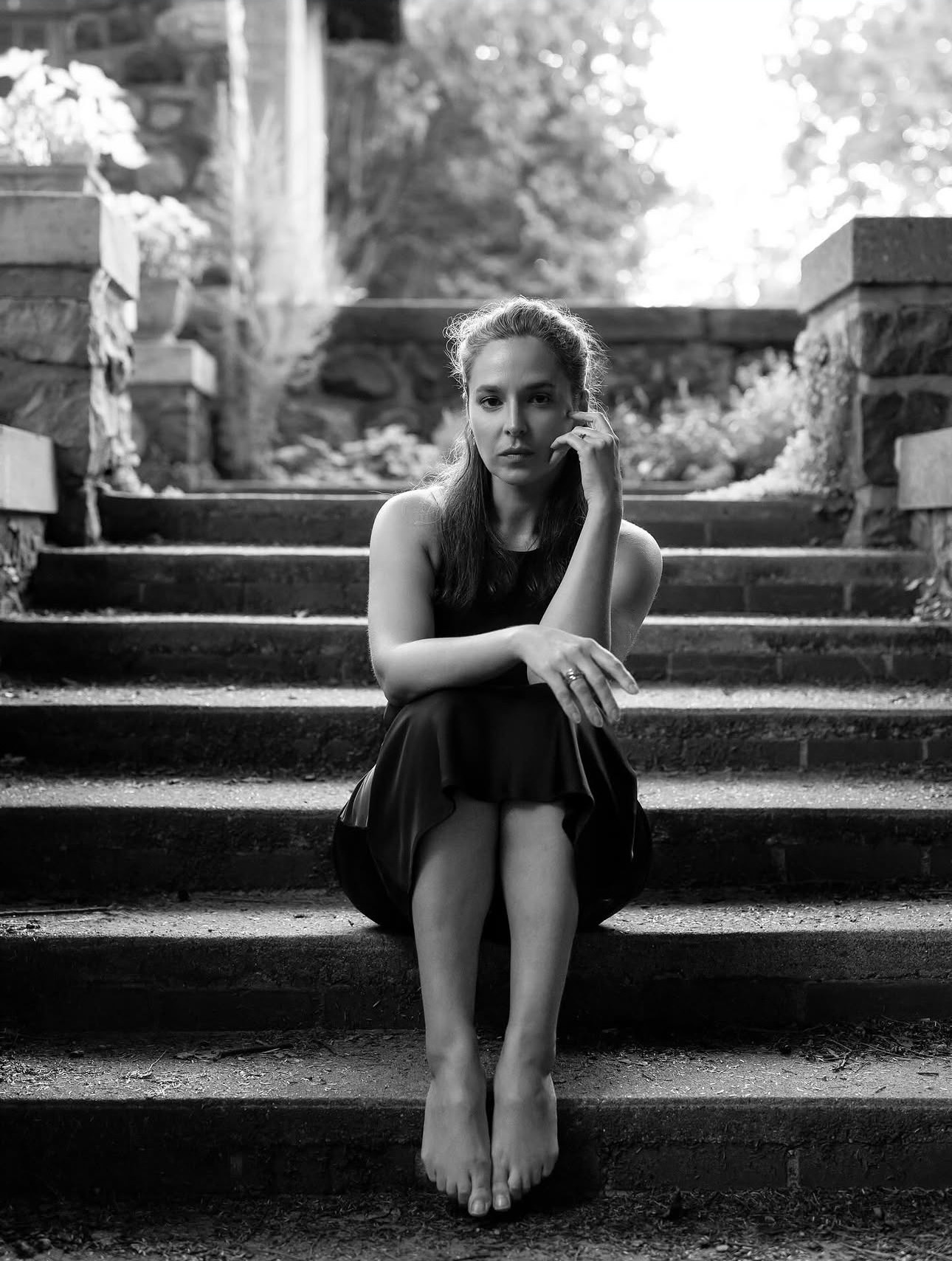 Black and white — seated on stone steps in a garden